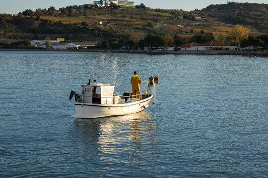 a fisherman catches fish on a small fishing boat