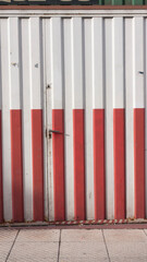 Puerta de chapa metálica de lineas blancas y rojas