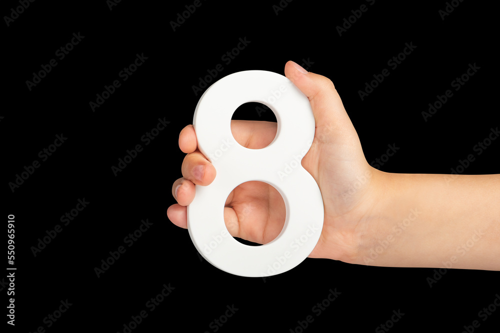 Poster number eight in hand isolated on black background. number 8 in a child's hand on a black background.