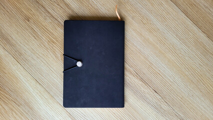 closed black cover diary with marker for text