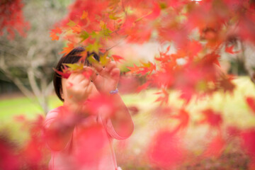 紅葉が綺麗な公園で自然を楽しむ3歳の女の子