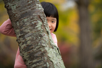 紅葉が綺麗な公園で自然を楽しむ5歳の女の子