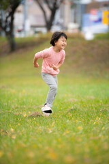 公園でかけっこして遊んでいる5歳の女の子