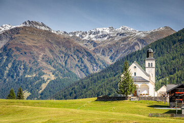 Fototapeta na wymiar Idyllic landscape of church in Engadine valley, Swiss Alps, Switzerland