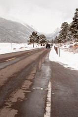 A car travels down the highway in Rocky Mountain National Park, Estes Park Colorado