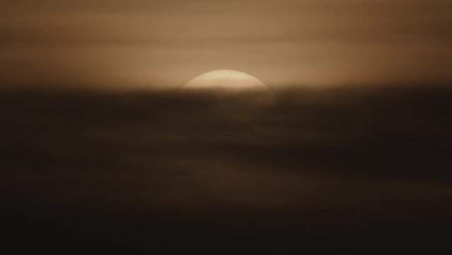 Time lapse of sun rising at sunrise behind clouds / Cisco, Utah, United States