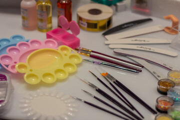 Make-up products, brushes, trays in blue, pink, yellow.