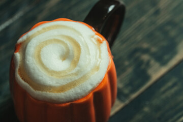 Latte in the pumpkin shaped coffee cup