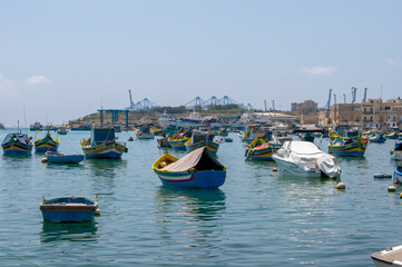 Fototapeta na wymiar Traditional luzzu boats on harbour, Marsaxlokk, Malta