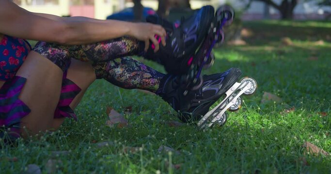 A woman straps on her roller blades at a park on a sunny day in the Caribbean
