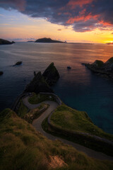 Shy Sun &bull; Dunquin Pier, the wild link to Great Blasket Island, is watching a calm and quiet sunset.