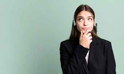 young pretty woman thinking, feeling doubtful and confused. telemarketing agent concept