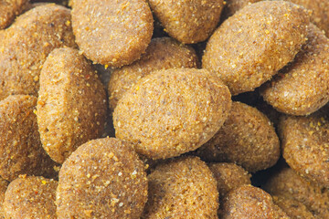 Fototapeta na wymiar Animal feed. Round shaped dry dog or cat food as background macro.