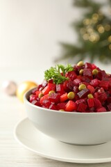 Traditional Russian salad vinaigrette on white wooden table, closeup
