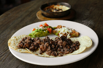 Plate with delicious tacos served on wooden table