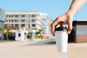 Woman holding takeaway coffee cup outdoors, closeup. Space for text