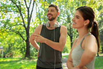 Fototapeta premium Man and woman talking before morning exercise in park