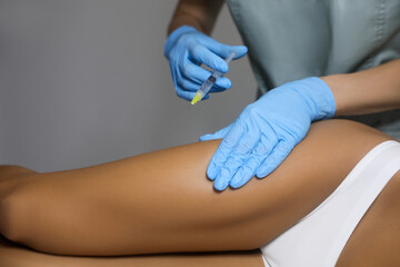 Young woman getting legs injection in salon, closeup