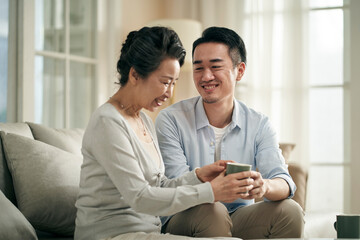 asian adult son and senior mother having a pleasant conversation at home