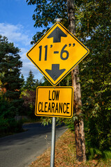 Yellow road sign, Low Clearance of 11’ 6”, caution to tall vehicles
