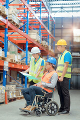 The supervisor is handicapped with a wheelchair inspecting the work background in warehouse.logistic  business export ,Warehouse worker checking packages on store