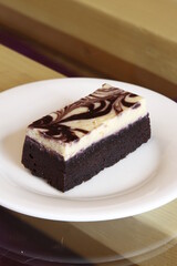 Chocolate marble brownie piece on a glass and wood table