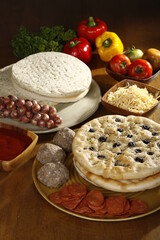 Pizza ingredients laid out on a wood table