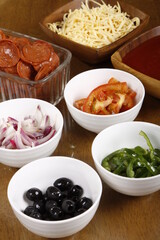 Pizza ingredients laid out on a wood table