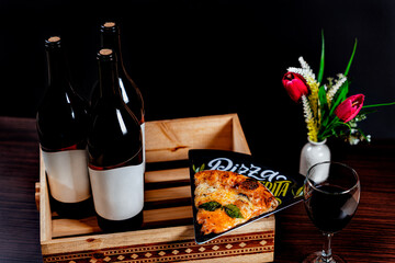 elegant lunch. bottle of wine with gourmet pizza. beverage and food served at the table. wine served by the glass with bottles. slice of traditional pizza.   