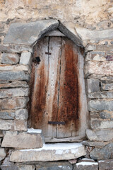 Fototapeta na wymiar Old wooden door in abandoned Galiat village in winter. Mountain Digoria, North Ossetia, Russia.
