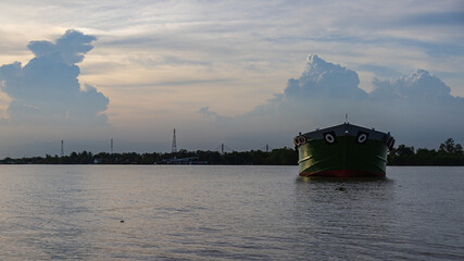 Sunset at the Mekong delta near Ho Chi Minh City. Massive cloud formations push ahead of the...