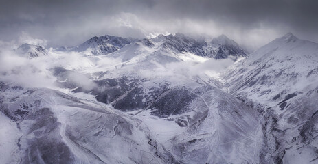 Panoramic aerial view of Caucasian Mountains above Dunta village after winter snowfall. Mountain Digoria, North Ossetia, Russia.