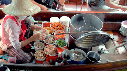 Sellers selling Thai noodle on boats, Ancient travel destination of Thailand Damnoen saduak flating market, Ratchaburi Thailand. © Atiwat