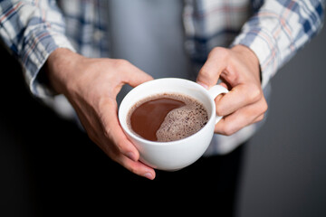 person holding white cup of coffee and drink it on a winter cold day