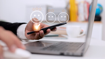 Customer service evaluation concept. using a smartphone is pressing face emoticon smiling in...