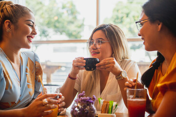 Three women friends drinking a coffee in a bar