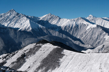Fototapeta na wymiar Caucasian winter landscape. View from Tsey Loam pass on sunny day. Ingushetia, Caucasus, Russia.