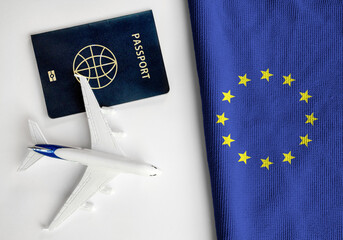 Flag of European Union with passport and toy airplane. Flight travel concept
