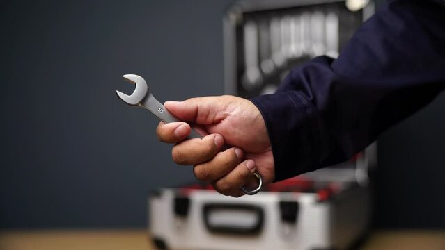 Mechanic holding open-ended wrench from toolbox. Wrench. Car repair kit in toolbox. mechanic tool set Inside the toolbox there are different types of wrenches