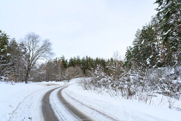Snowy winter road in a mountain forest.