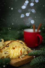 Fototapeta na wymiar Pieces of Christmas cake on a board, a red cup of tea and blurred lights like steam, Merry Christmas and Happy New Year
