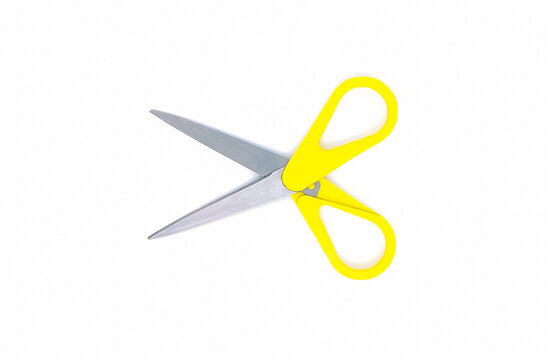 Scissors with yellow handle isolated on white background. Selective focus. Top view or flat lay.