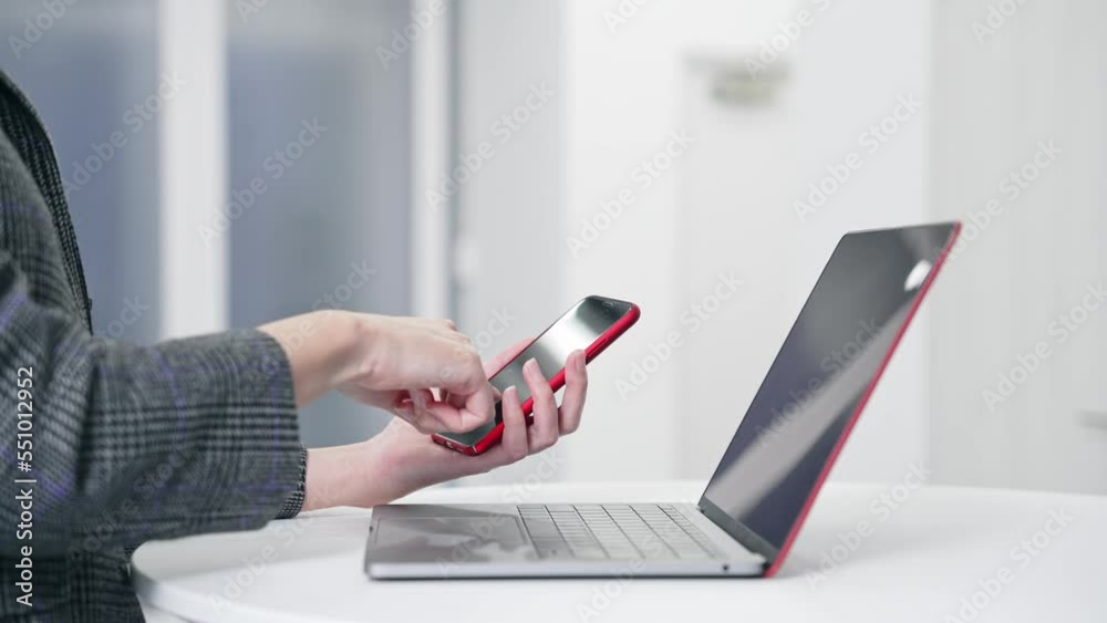 Aufkleber Woman using smartphone and laptop in office. smartphone authentication. biometric authentication. Security.