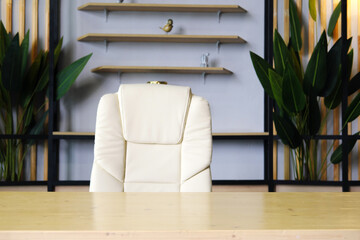 Modern white office interior with stylish decor. A white armchair stands near a light wooden table