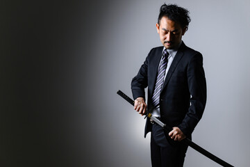 A businessman in a suit holding a sword.