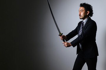 A businessman in a suit holding a sword.