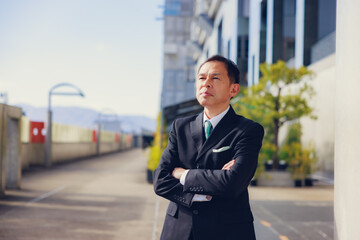 Fototapeta premium Middle-aged Asian man in black business suit at Kyoto station, Japan.