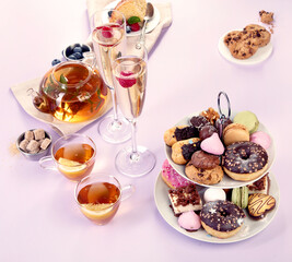 Traditional English tea. Afternoon tea with  selection of sweets  on violet background. Holiday concept