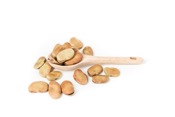 Fava beans scattered around a wooden spoon isolated over white top down view