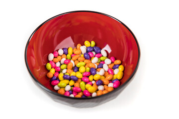 Fennel seed candy in a black bowl with reflections isolated over white